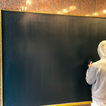Mitarbeiter trägt eine hochwertige Effektbeschichtung auf eine große Wandfläche im Nationalgericht Berlin auf