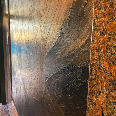 Strukturierte Metalloptik auf einer großen Wandfläche im Nationalgericht Berlin
