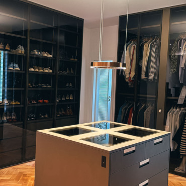 Begehbarer Kleiderschrank mit maßgefertigten Einbauten und Designbeleuchtung