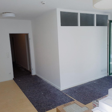 Wohnraum mit neu gestalteten Wänden und vorbereitetem Boden nach der Renovierung