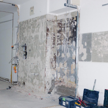 Freigelegte Wand mit entfernten Altbelägen während der Sanierung