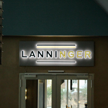 Beleuchteter Eingangsbereich des Lanninger Restaurants mit beleuchtetem Logo