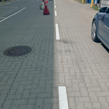 Weiße Parkplatzmarkierung auf einer gepflasterten Verkehrsfläche