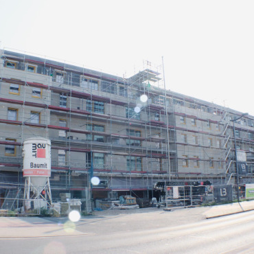 Mehrgeschossiger Neubau mit Fassadengerüst während der Bauphase