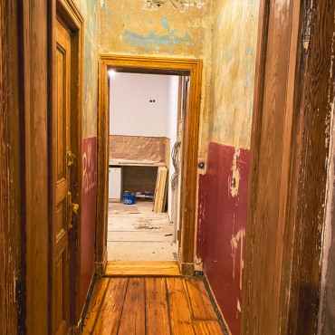 Flur einer Altbauwohnung während der Sanierungsarbeiten mit freigelegten Wandflächen