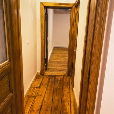 Renovierter Flur mit aufgearbeitetem Holzboden und historischen Türen
