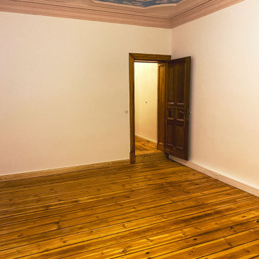 Modernisierter Wohnraum mit restauriertem Holzboden und frisch gestrichenen Wänden