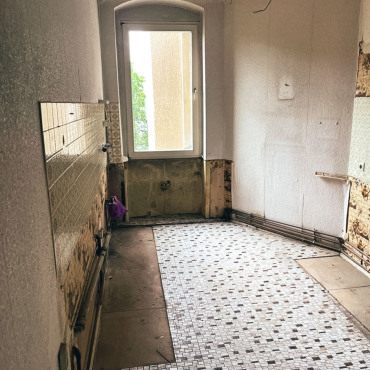 Küche einer Altbauwohnung vor der Sanierung mit freigelegten Wandflächen
