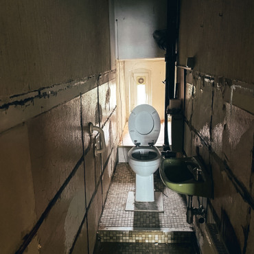 Badezimmer während der Entkernung mit freigelegten Installationen