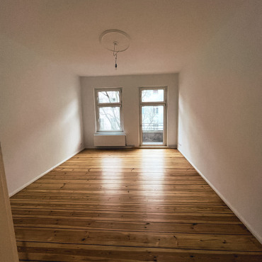 Fertig renoviertes Wohnzimmer mit aufgearbeitetem Dielenboden