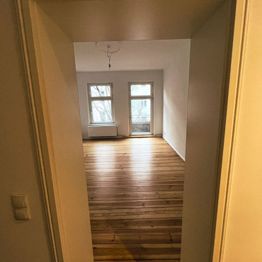 Blick in ein fertig saniertes Wohnzimmer mit historischen Fenstern