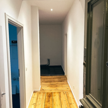 Eingangsbereich einer sanierten Altbauwohnung mit restauriertem Dielenboden