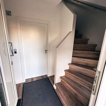Flur mit neuer Treppe und frisch gestalteten Wandflächen