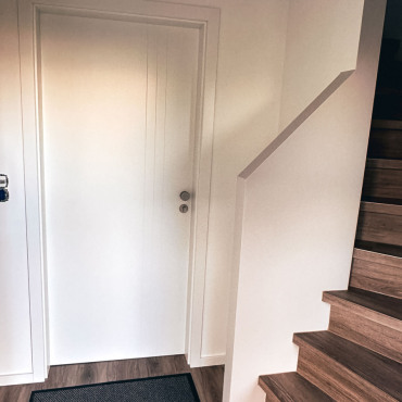 Flur mit moderner Treppe und hellen Wandflächen
