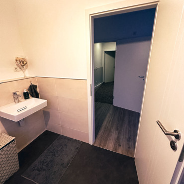 Modernisiertes Badezimmer mit Waschtisch und neuem Bodenbelag