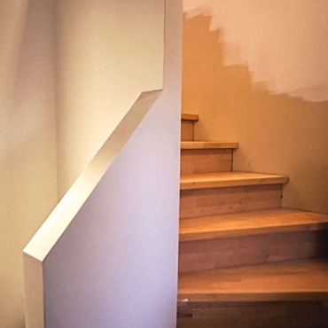 Detailaufnahme einer renovierten Holztreppe mit neuen Stufen
