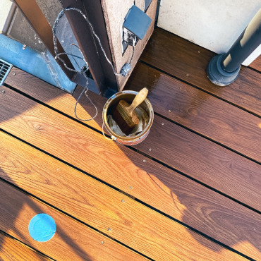 Detailaufnahme beim Auftragen von Terrassenöl auf Holzdielen