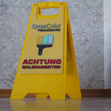 Warnschild „Achtung Rutschgefahr“ auf einer Baustelle während der Malerarbeiten
